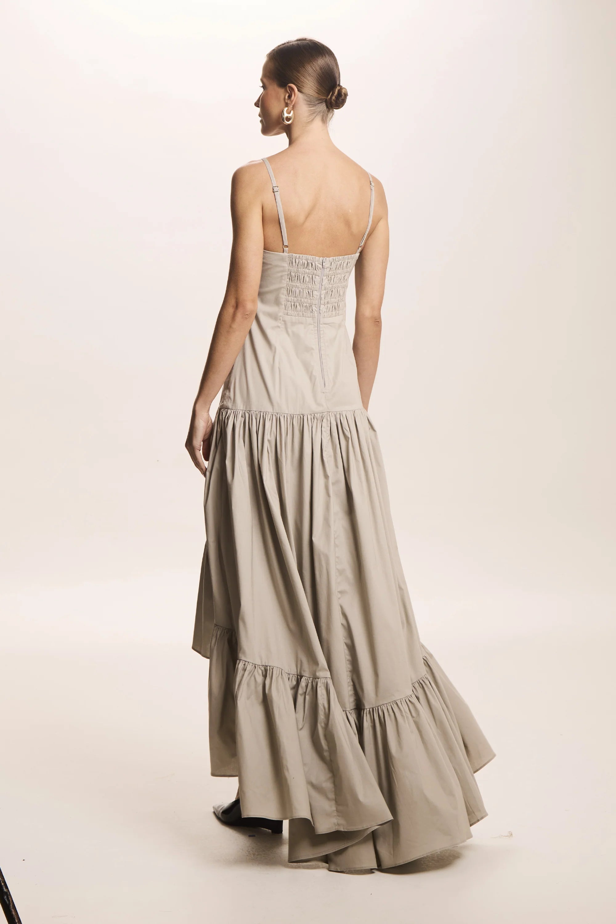 Es un vestido de fiesta largo color beige de mujer